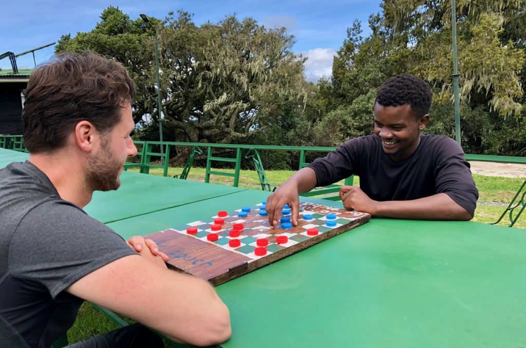 Mountaineers at Mount Meru play checkers at camp