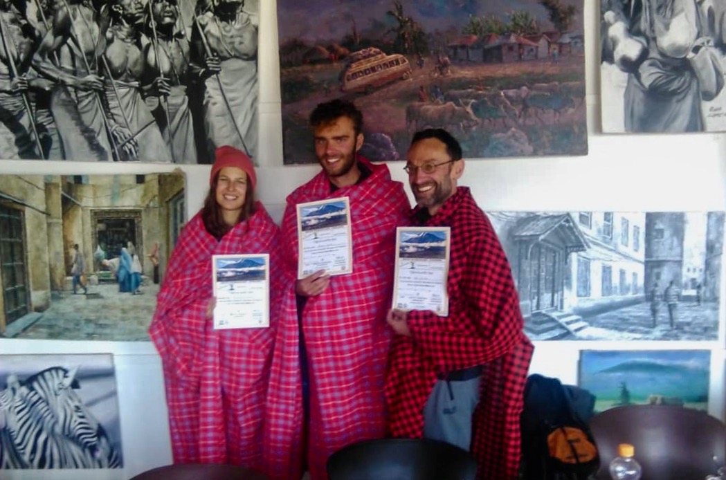 Trois alpinistes après une ascension réussie du Kilimandjaro